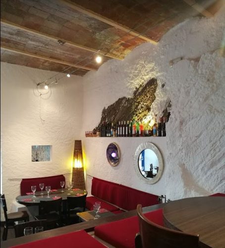 El interior del restaurante Celeste, donde la roca, pintada de blanco se funde con las paredes