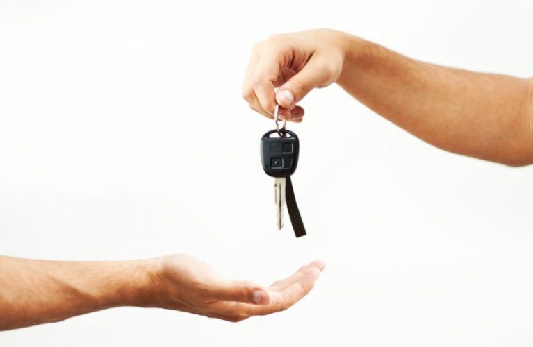 En la foto dos manos, una entregando las llaves de un vehículo a otro