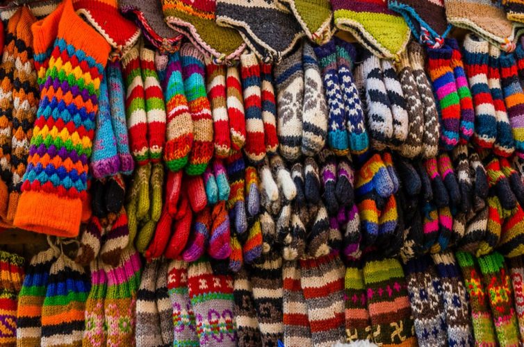 Imagen con un montón de ropa de lana colgada como una tienda de mercado