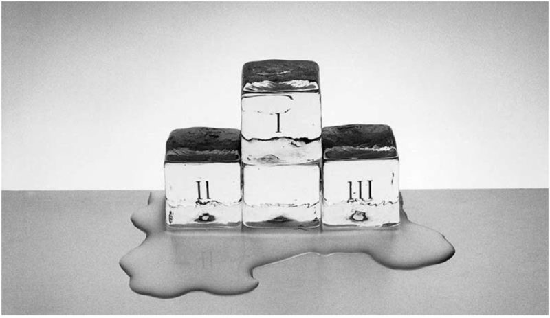 Foto artística en blanco y negro de tres cubitos de hielo formando un podium que se derrite