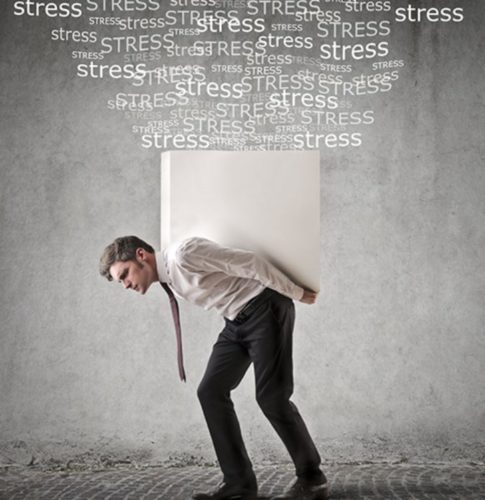 Foto de un hombre ejecutivo con un gran bloque blanco sobre las espaldas y encima muchas palabras de stress