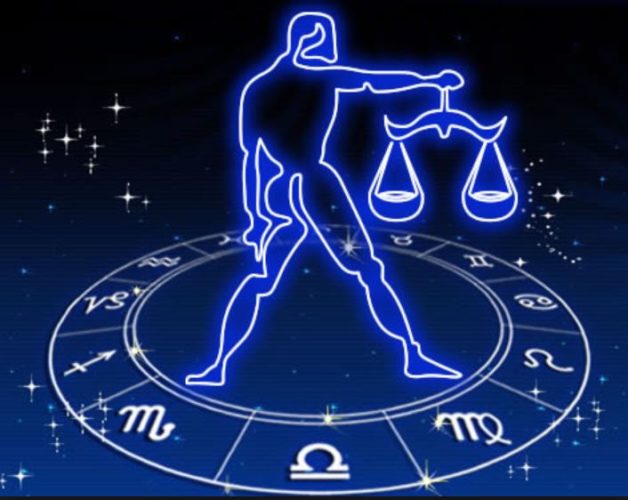 En la imagen el símbolo de libra, la balanza sostenido por una persona de pie sobre el círculo del zodiaco