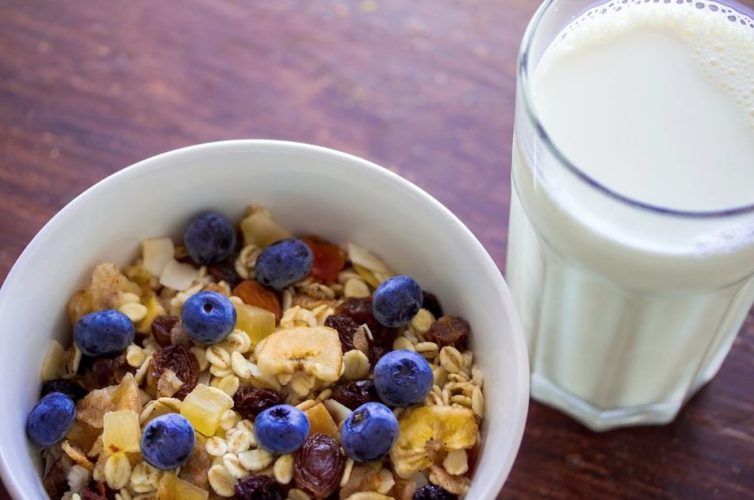 En la foto un bol de cereales con un vaso de leche de avena al lado