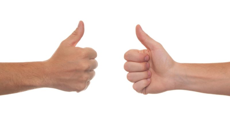 Imagen de dos manos frente a frente con el pulgar levantado hacia arriba, recortadas sobre un fondo blanco