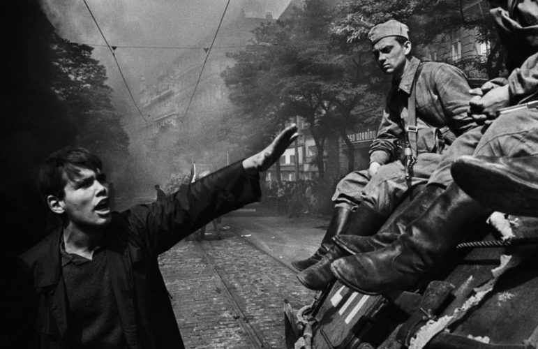 Imagen de un checoslovaco con mano en alto oponiéndose a un tanque soviético