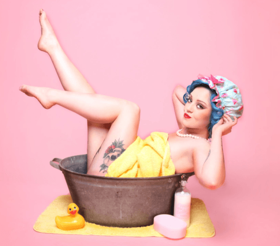 Chica Pin up dentro de un barreño de baño enseñando tatuaje de calavera en las piernas