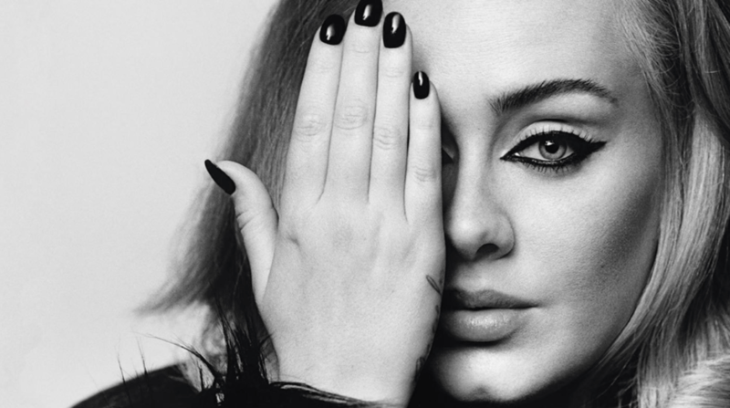 En la foto la cantante Adele tapándose con la mano su ojo derecho