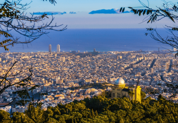 Foto panorámica de la ciudad de Barcelona con el mar de fondo, hecha desde una montaña