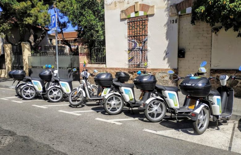 En la foto se muestra un aparcamiento de motos con 5 espacios ocupado por 7 motos, todas de la misma empresa de moto sharing, Cooltra
