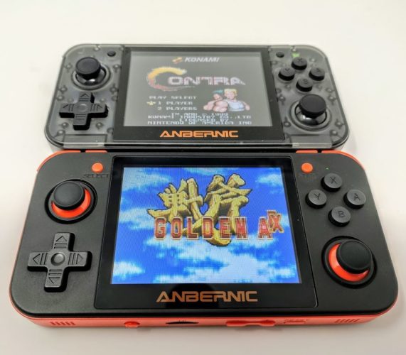 Dos consolas RG350, la primera en color negro y naranja corriendo Golden Axe, y la segunda, colocada encima, de color negro translúcido corriendo el videojuego Contra