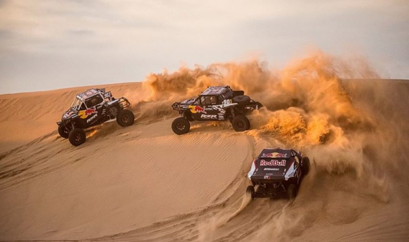 En la foto observamos tres buggies de RedBull subiendo una duna del desierto