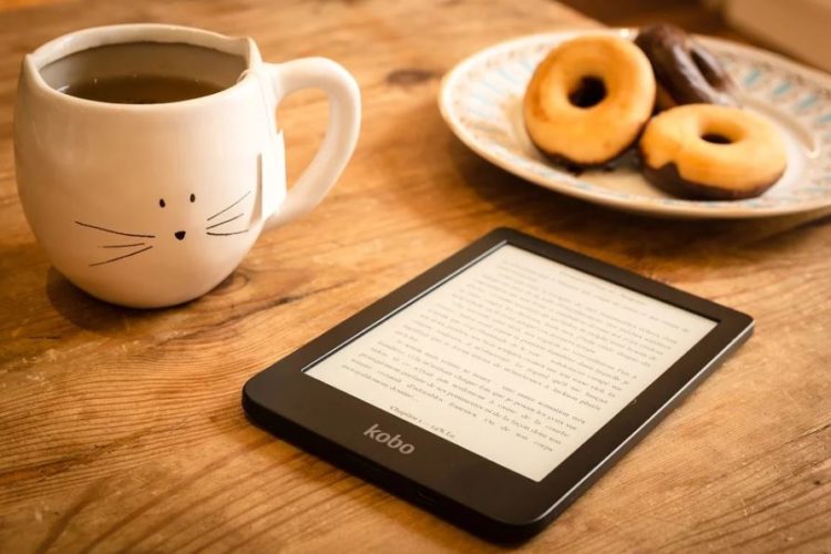 En la foto un libro electrónico del fabricante Kobo, una taza de café y unas deliciosas rosquillas